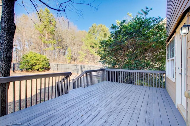 wooden terrace with a fenced backyard