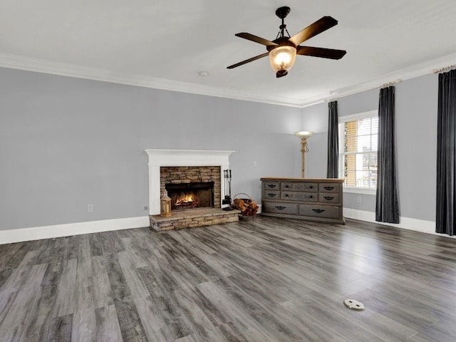 unfurnished living room featuring ceiling fan, crown molding, a fireplace, wood finished floors, and baseboards