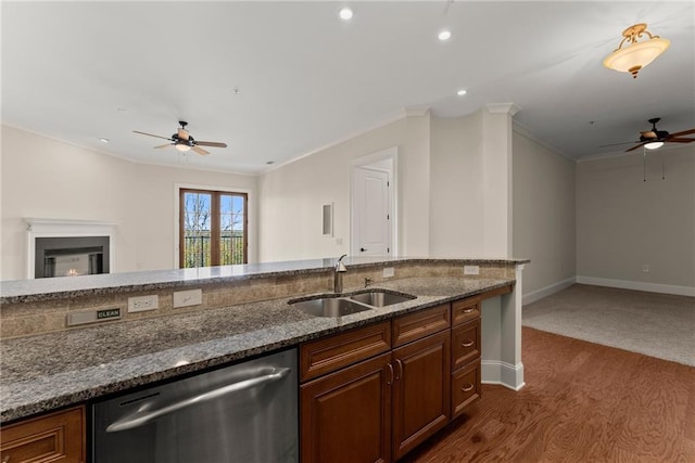 kitchen featuring sink, dark stone countertops, dark hardwood / wood-style flooring, ornamental molding, and stainless steel dishwasher