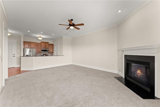 unfurnished living room with ornamental molding, carpet floors, and ceiling fan