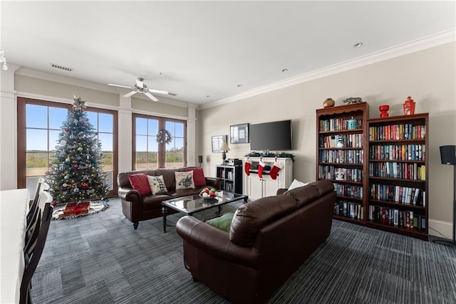 living room with dark colored carpet, ornamental molding, and ceiling fan