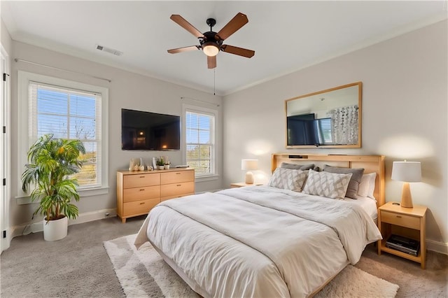 carpeted bedroom with ceiling fan and ornamental molding