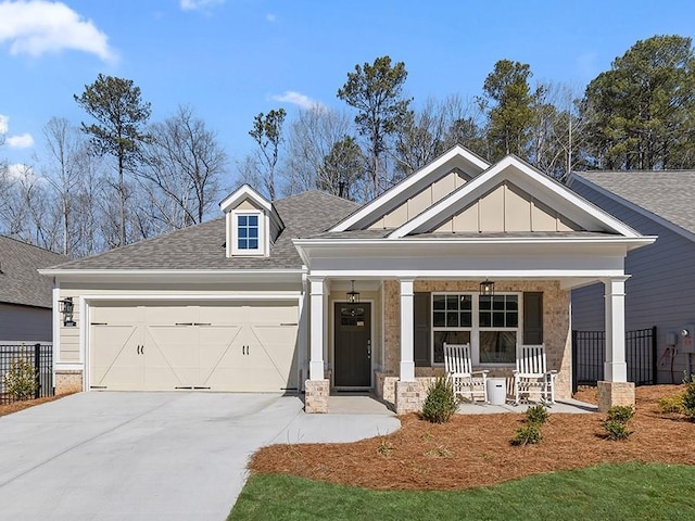 craftsman house with driveway, a shingled roof, an attached garage, covered porch, and board and batten siding