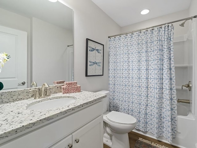 bathroom featuring shower / bathtub combination with curtain, vanity, toilet, and wood finished floors