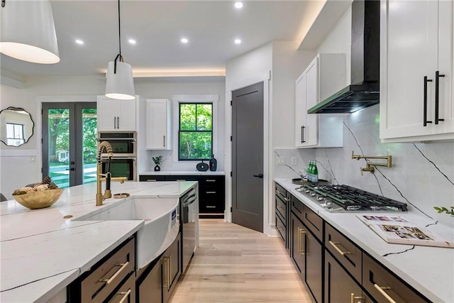 136 Beutell St, Norcross, GA 30071 - kitchen with wall chimney exhaust hood, stainless steel appliances, white cabinets, a sink, and light wood-style floors