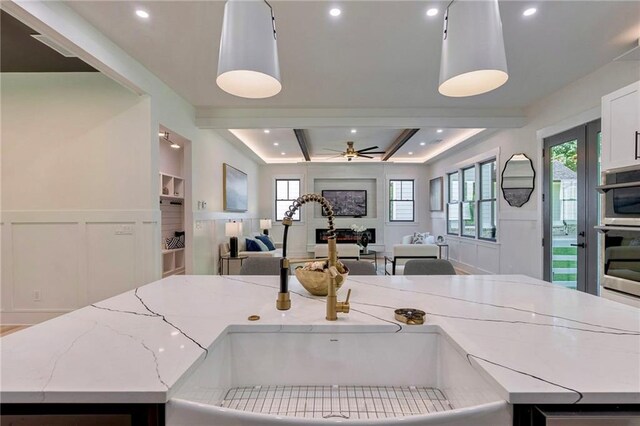136 Beutell St, Norcross, GA 30071 - kitchen featuring a sink, open floor plan, a decorative wall, ceiling fan, and a wainscoted wall