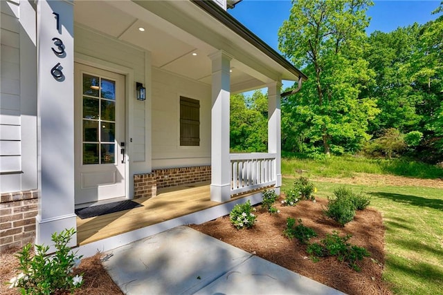 136 Beutell St, Norcross, GA 30071 - doorway to property featuring covered porch and brick siding