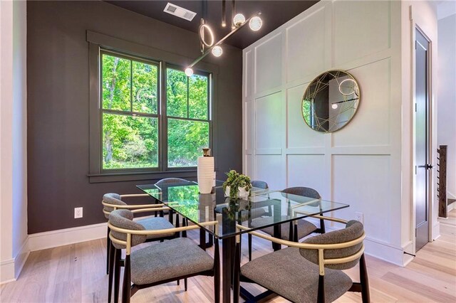 136 Beutell St, Norcross, GA 30071 - dining room featuring plenty of natural light, light wood finished floors, baseboards, a decorative wall, and a chandelier