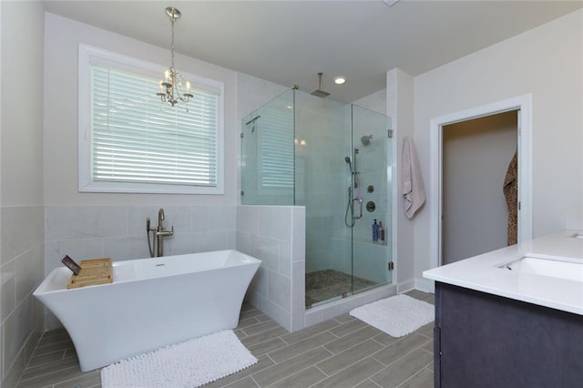 451 Burton Dr Unit 32, Alpharetta, GA 30009 - bathroom featuring a stall shower, a sink, a soaking tub, tile walls, and a chandelier