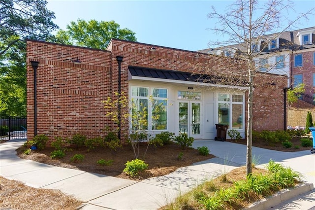 451 Burton Dr Unit 32, Alpharetta, GA 30009 - view of front of house with french doors, brick siding, a standing seam roof, and fence