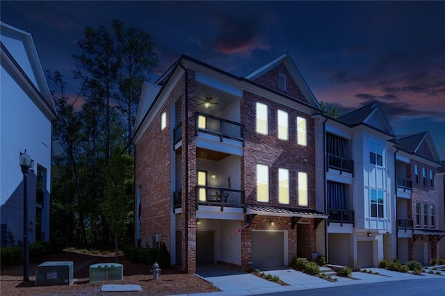 451 Burton Dr Unit 32, Alpharetta, GA 30009 - view of front of home featuring a balcony, an attached garage, brick siding, driveway, and central AC unit