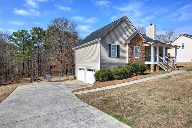 view of front of house with a garage, covered porch, and a front yard