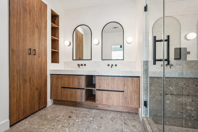 bathroom featuring double vanity, a stall shower, and a sink
