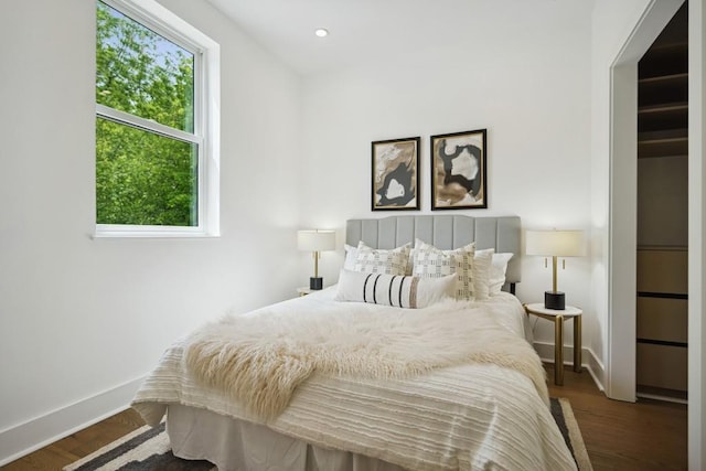 bedroom with recessed lighting, wood finished floors, and baseboards