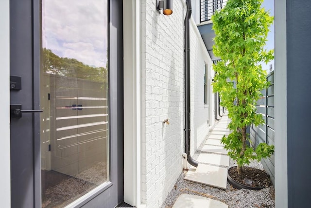 doorway to outside featuring brick wall