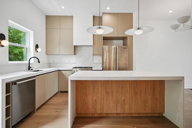 kitchen featuring light countertops, light wood-type flooring, appliances with stainless steel finishes, and a sink