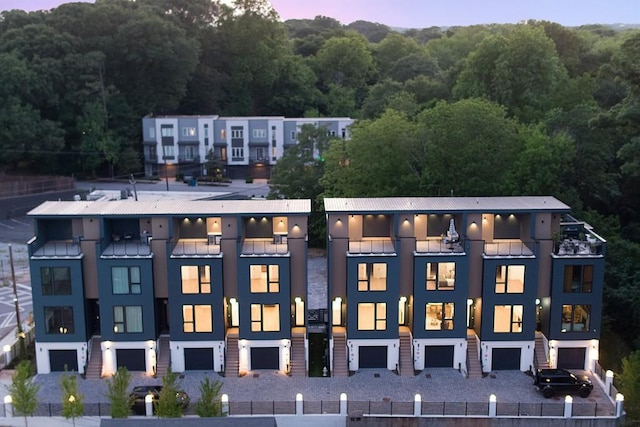 property at dusk with a wooded view