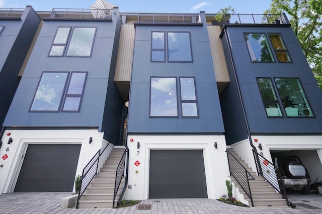 view of front of property featuring stairway, stucco siding, and a garage