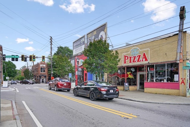 view of street with traffic lights, sidewalks, and curbs