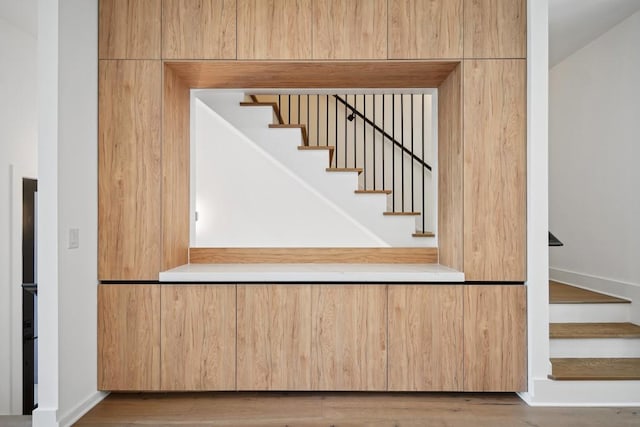 stairway with baseboards and wood finished floors