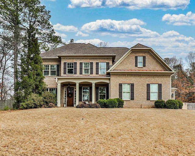 traditional-style house featuring brick siding and a front yard