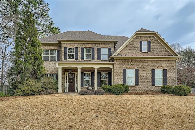 view of front of house featuring a front lawn and brick siding