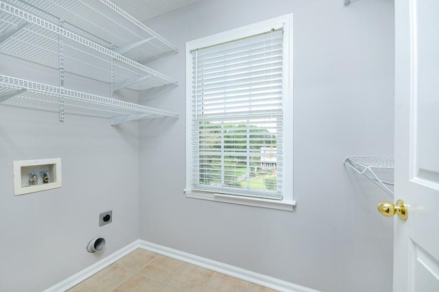 clothes washing area featuring washer hookup, electric dryer hookup, and light tile patterned flooring