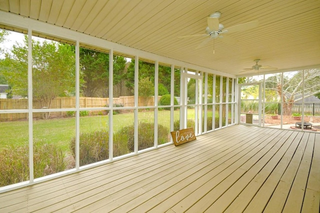 unfurnished sunroom featuring ceiling fan