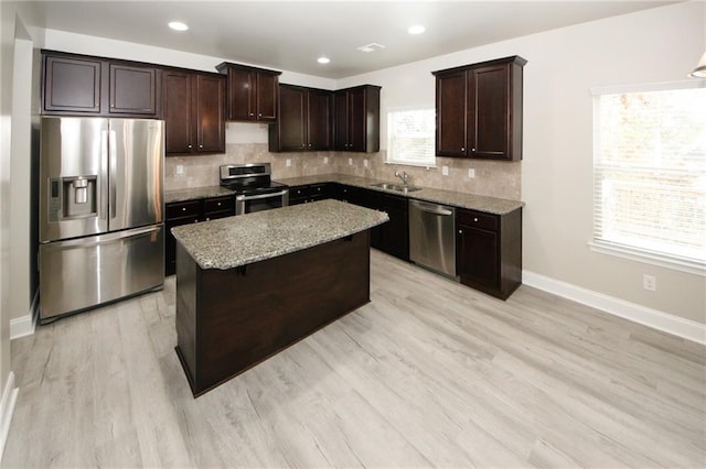 kitchen featuring sink, a kitchen island, a healthy amount of sunlight, and appliances with stainless steel finishes