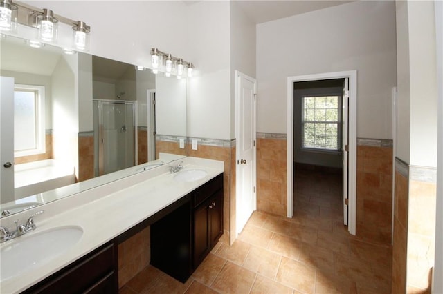 bathroom featuring tile patterned flooring, vanity, separate shower and tub, and tile walls