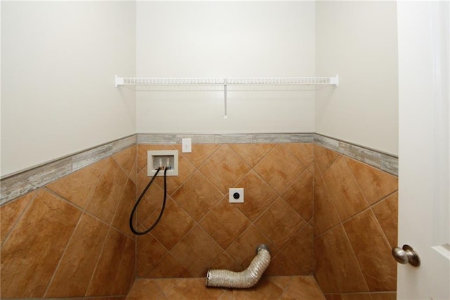 washroom with hookup for an electric dryer, washer hookup, and tile walls