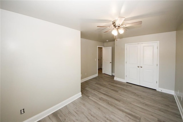 unfurnished bedroom with wood-type flooring, a closet, and ceiling fan