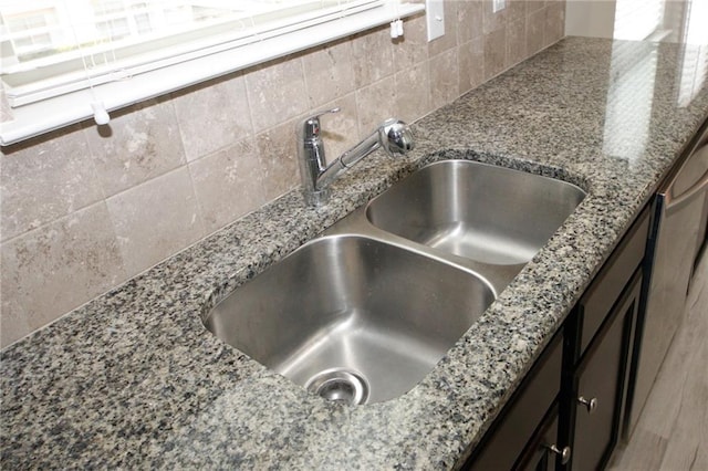 room details with stone counters, backsplash, and sink