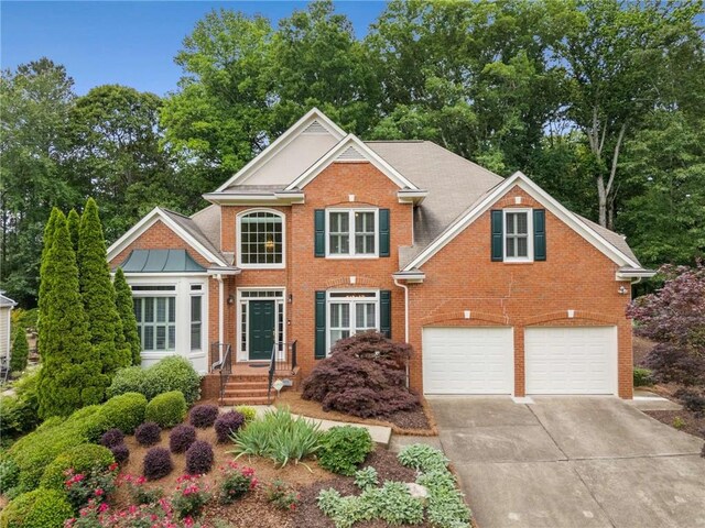 2026 Cresthaven Walk, Woodstock, GA 30189 - view of front of property with driveway, brick siding, a garage, and view of scattered trees