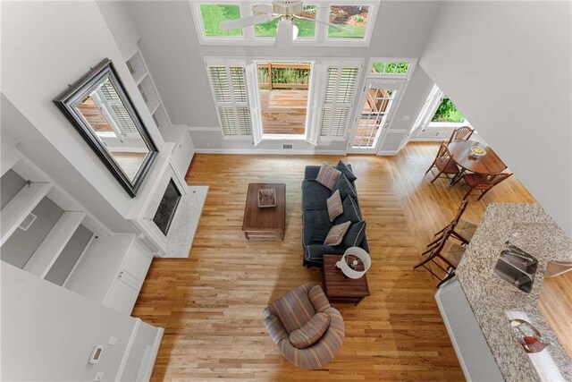 2026 Cresthaven Walk, Woodstock, GA 30189 - living room with a high ceiling, ceiling fan, light wood finished floors, and baseboards