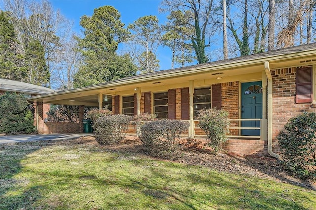 ranch-style house featuring a front lawn and a carport