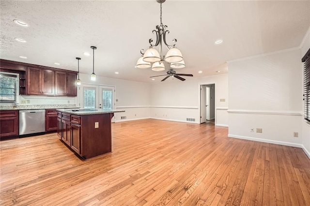 kitchen featuring dishwasher, light wood-type flooring, pendant lighting, a kitchen island, and ceiling fan with notable chandelier