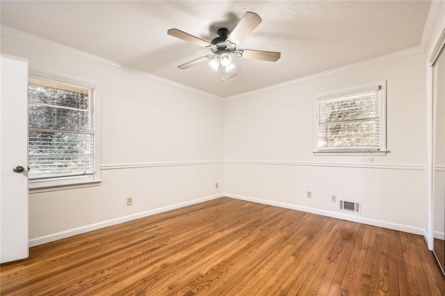 empty room featuring ceiling fan, hardwood / wood-style flooring, and crown molding