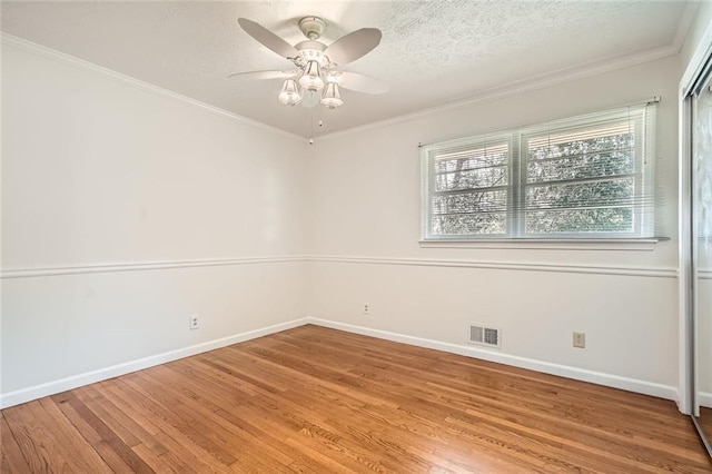 empty room featuring wood-type flooring, ceiling fan, and crown molding