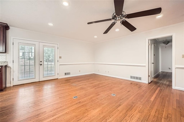 interior space featuring light wood-type flooring, french doors, ceiling fan, and crown molding