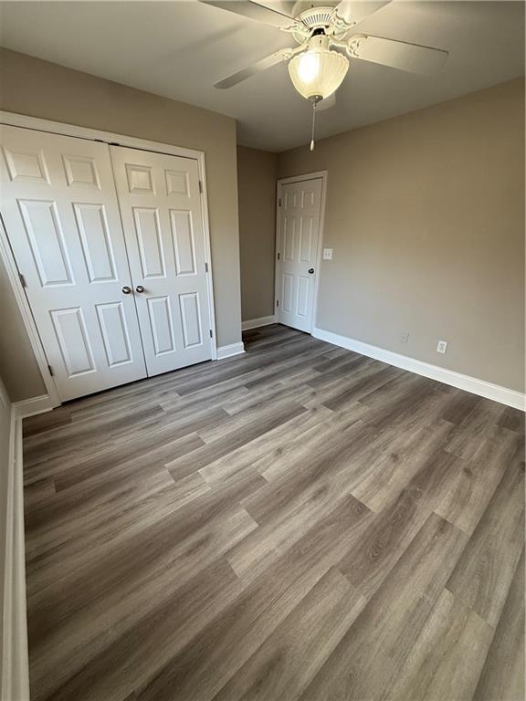 unfurnished bedroom with light hardwood / wood-style flooring, ceiling fan, and a closet