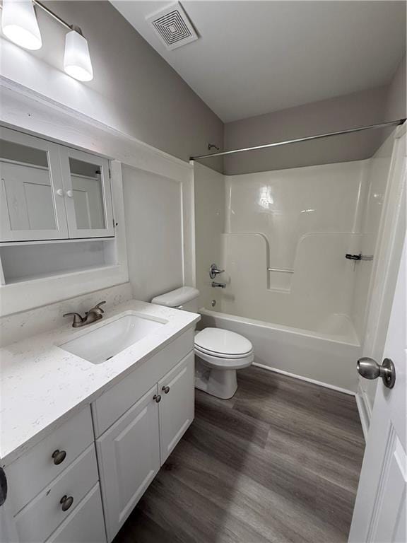 full bathroom with hardwood / wood-style flooring, vanity, toilet, and shower / washtub combination