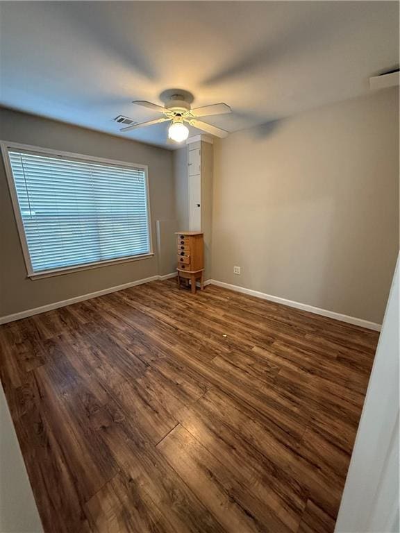 spare room with ceiling fan and dark hardwood / wood-style floors