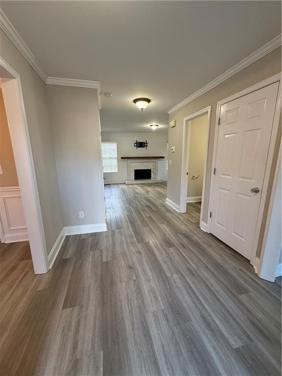 unfurnished living room with hardwood / wood-style floors and crown molding