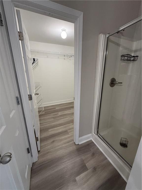 bathroom with hardwood / wood-style floors and an enclosed shower