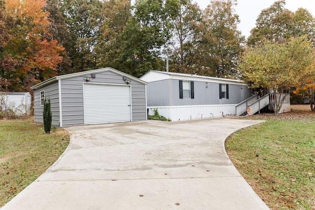 manufactured / mobile home featuring an outdoor structure, a front lawn, and a garage