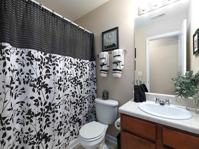 bathroom with walk in shower, vanity, and toilet