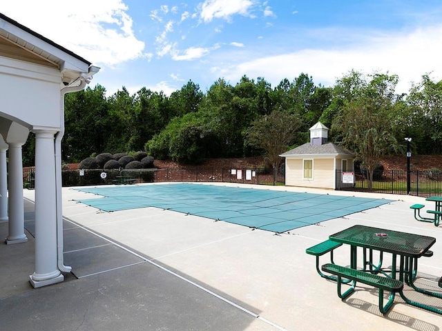 view of pool with a patio area and an outbuilding