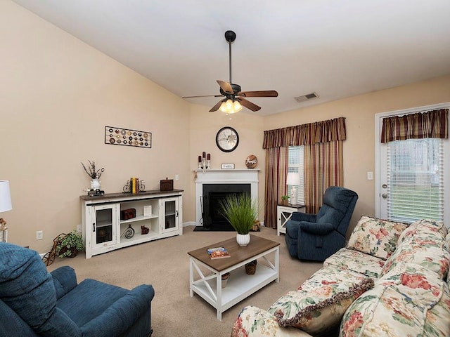 carpeted living room with ceiling fan and vaulted ceiling