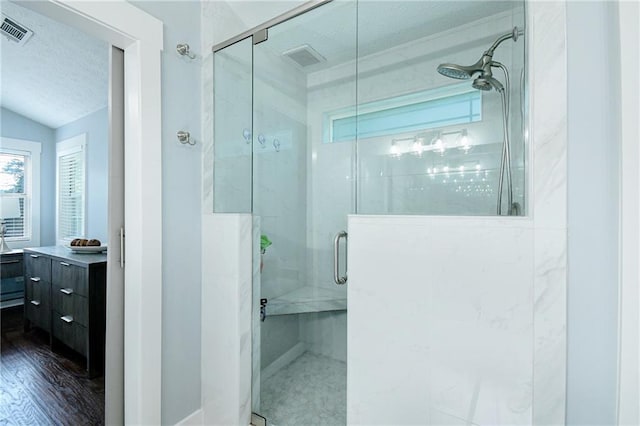 787 Mckendree Lake Way, Lawrenceville, GA 30043 - bathroom featuring a stall shower, a textured ceiling, wood finished floors, and vanity